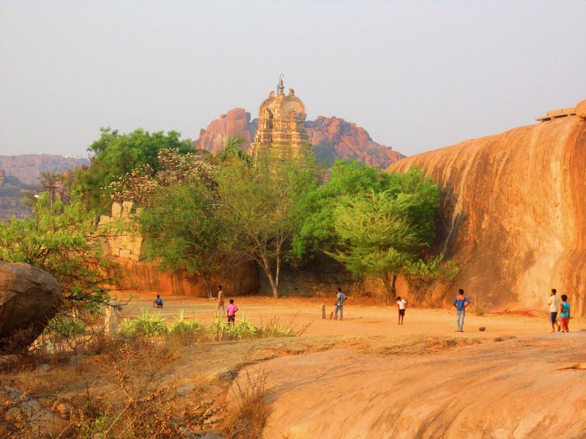 Enfants jouant au cricket au milieu des ruines de Hampi