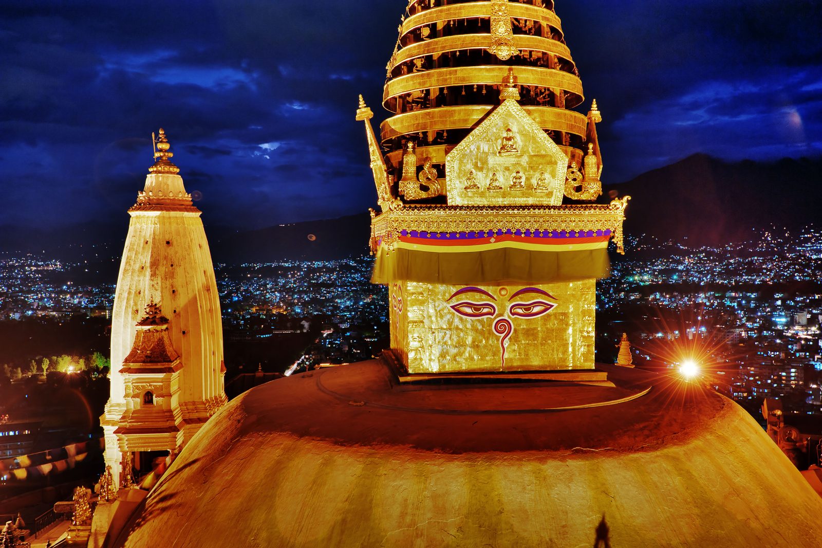 Les yeux de Bouddha du stupa de Swayambhunath, illuminés à la nuit tombée